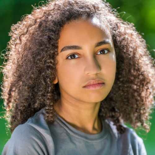 Young BIPOC teen staring blankly