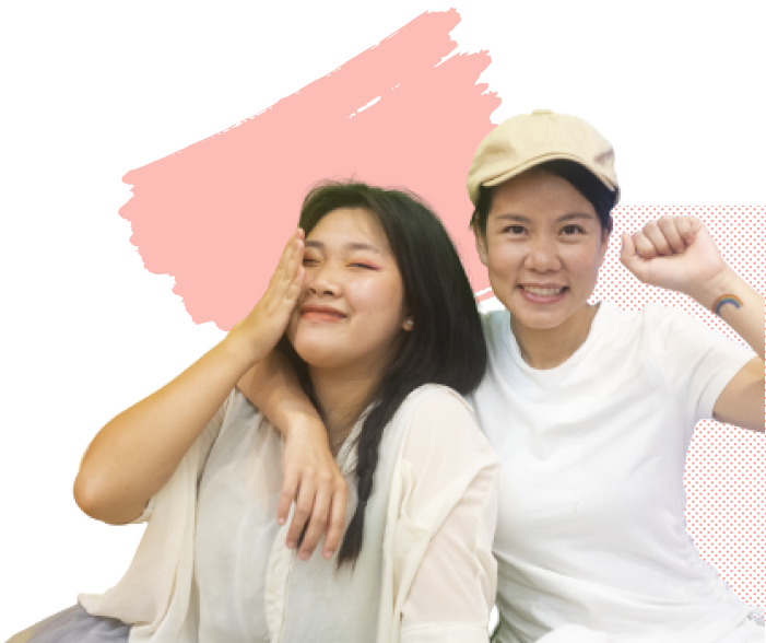 Two smiling Asian women, one holding her fist in the air with joy